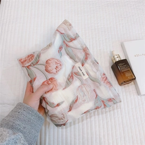 Gros plan d'une pochette en jacquard à tulipes avec étiquette dans un décor élégant