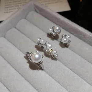 Elegant silver pearl jewelry set with zircon accents displayed on a grey velvet tray