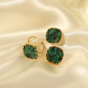 Detailed view of square green turquoise jewelry set on silk including ring and earrings