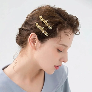 Stylish gold butterfly hair clips with white rhinestones on model side profile
