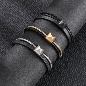 Détail macro de bracelets multicouches en cuir tressé avec des clous dorés argentés noirs