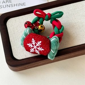 Close-up of Christmas scrunchie with red sequin candy, green plush and metal bells