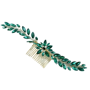 Macro detail of gold-tone hair comb with deep green marquise crystal leaf ornaments