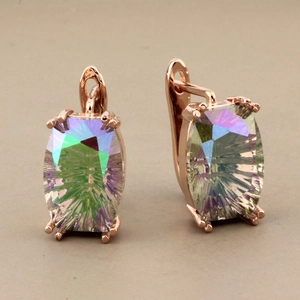 Macro detail of rose gold lever-back earrings with vibrant mystical rainbow gemstones