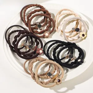 Detail of high-elasticity hair ties with floral charms and crystals in earth tones