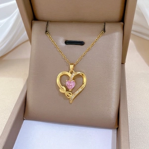Elegant gold titanium heart necklace with pink stone and small white crystals in a box