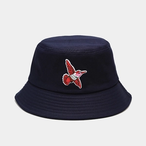 Close-up of hummingbird embroidery on navy blue cotton bucket hat with detailed stitching