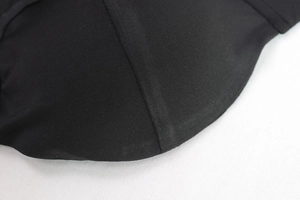 Gros plan sur les coutures de précision et la texture mesh de la robe moulante noire