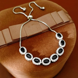 Detail of adjustable silver bracelet with seven oval black gems and zircon accents