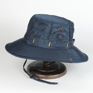 Dark blue wide brim sun hat with adjustable strap and metal vents on a wooden stand