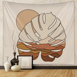 Detail of bohemian wall tapestry featuring monstera leaf and abstract sunset landscape