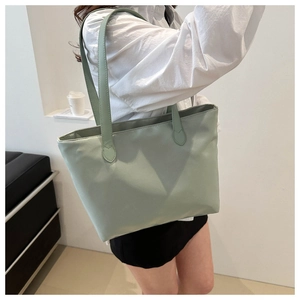 Close-up of a light green large-capacity tote bag with durable nylon shoulder straps