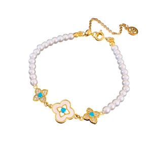 Bracciale di perle placcato oro 18k con ciondoli a trifoglio in zircone blu su fondo bianco