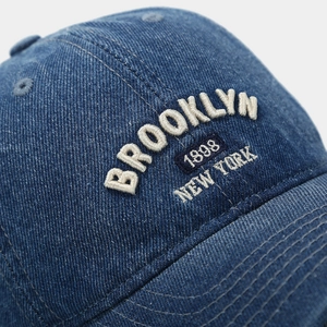 Gros plan sur la broderie 3D Brooklyn 1898 d'une casquette de baseball en denim vintage