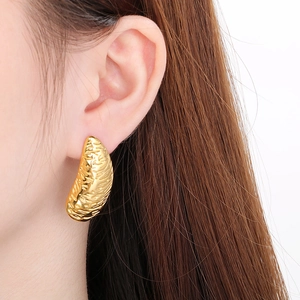 Golden irregular stainless steel earrings with hammer texture on a white background