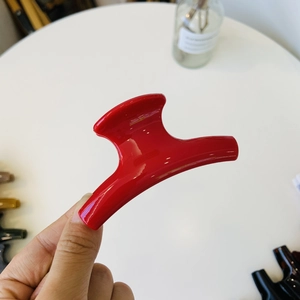Detail shot of a glossy red claw clip made of high-quality acrylic for French hairstyles
