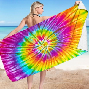 Detail showing the vibrant tie-dye pattern on a large microfiber beach towel held by a model