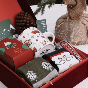 Christmas gift box featuring a Santa mug, festive socks, candle and Marvis toothpaste