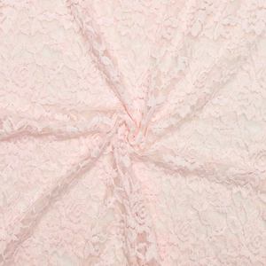 Detailed macro shot of pink lace fabric texture with elegant spiral fold patterns