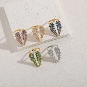 Detailed view of five angel wing rings with colorful zircon inlay in gold and silver plating