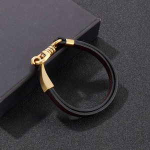 Detail of dark brown leather bracelet with gold metal U-hook clasp on a premium box