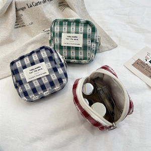 Detail of checkered canvas organizer bags showing internal storage and zipper closure