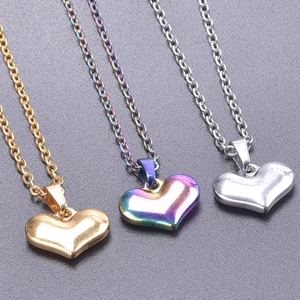 Detailed macro view of heart pendants in gold, silver, and rainbow 18k plated steel