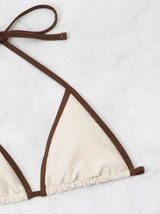 Close-up of beige textured triangle bikini top with contrast dark brown binding detail
