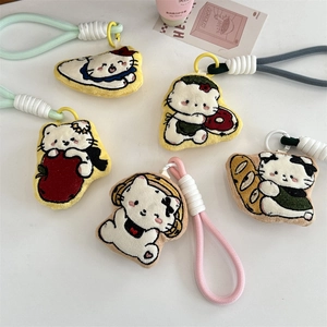 Close-up of plush cartoon cat charms with embroidery, donuts, and bread decorations