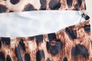 Detailed close-up of leopard print fabric with precise stitching on a tight dress