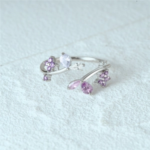 Macro shot of silver floral ring featuring purple pear-shaped crystals and open double layers