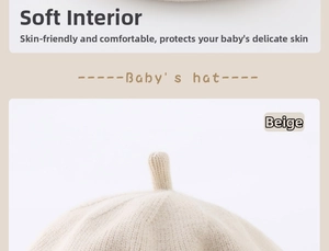 Detail view of beige baby knit beret showing soft textured fabric and top stem design