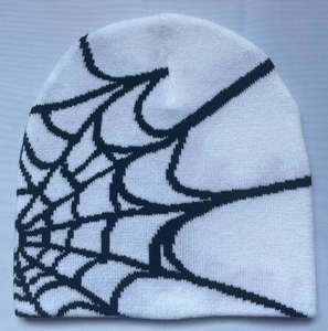 Detail of white knit beanie with black spider web pattern and high-quality knit texture