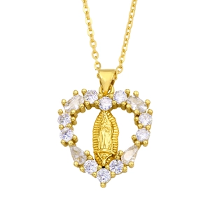 Macro view of gold heart pendant with micro-pave crystals and Virgin Mary relief