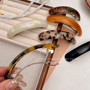 Macro detail of acetate spring hair clips in various colors with metal closure mechanism