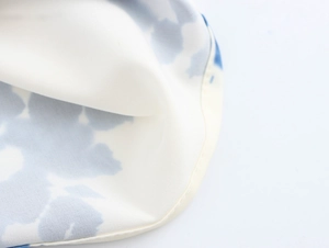 Close-up of lightweight fabric with blue geometric patterns and fine stitching detail