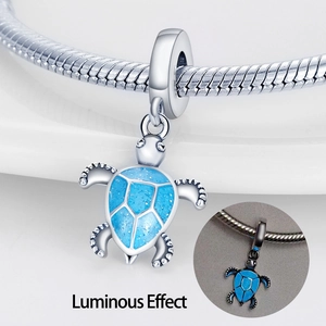 Luminous silver turtle charm with blue shell on bracelet showing night glow effect