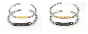 Detail of silver couple bracelets with engraved True Love on gold and black plates