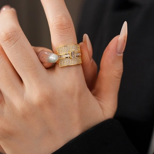 Close-up of gold wide-band ring with rectangular zircon and micro-pave crystals