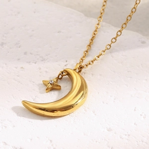 Detailed macro view of an 18K gold-plated crescent moon and sparkling star pendant