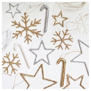 Flat lay of champagne gold and silver Christmas tree ornaments with glitter snowflake stars
