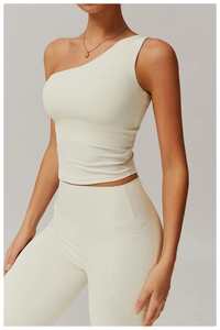 Detail of cream white one-shoulder sports top and high-waist yoga pants with side pockets