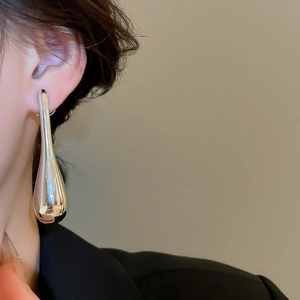 Silver teardrop earrings on model showing sleek metallic finish and minimalist design