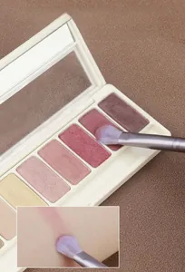 Détail macro d'un pinceau de maquillage doux avec fard à paupières et test cutané