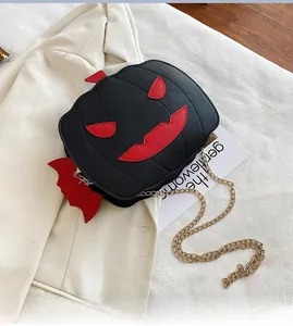 Detail of creative pumpkin bag with red bat wings and gold chain on stylish blazer