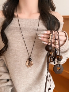 Detailed shot of ethnic wood and resin pendants with heart-shaped natural stone on a cord