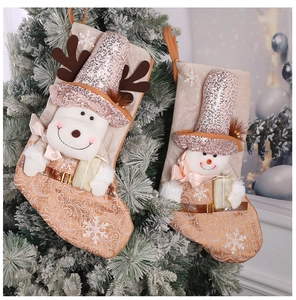 Close-up of sequined Christmas stocking featuring reindeer and snowman on a green tree