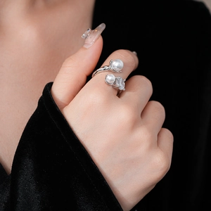 Detail of silver open ring featuring irregular pearls and cubic zirconia on a model hand