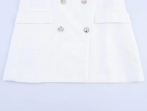 Close-up of double-breasted white blazer with silver buttons and flap pockets