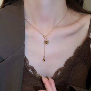 Gros plan d'un collier pendentif tournesol doré avec œil de tigre sur un mannequin